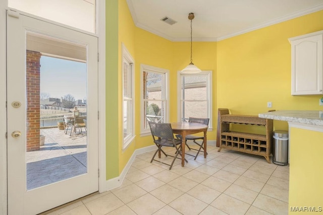 dining area featuring baseboards, light tile patterned flooring, visible vents, and crown molding