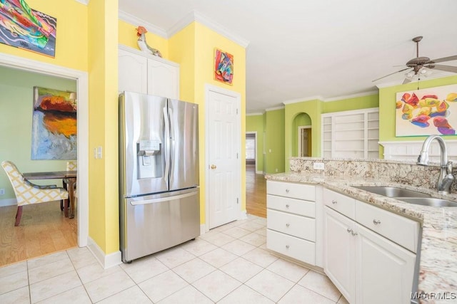 kitchen with light tile patterned floors, a sink, white cabinets, ornamental molding, and stainless steel refrigerator with ice dispenser