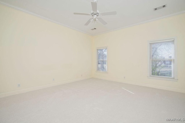 unfurnished room with light colored carpet, a ceiling fan, baseboards, visible vents, and ornamental molding