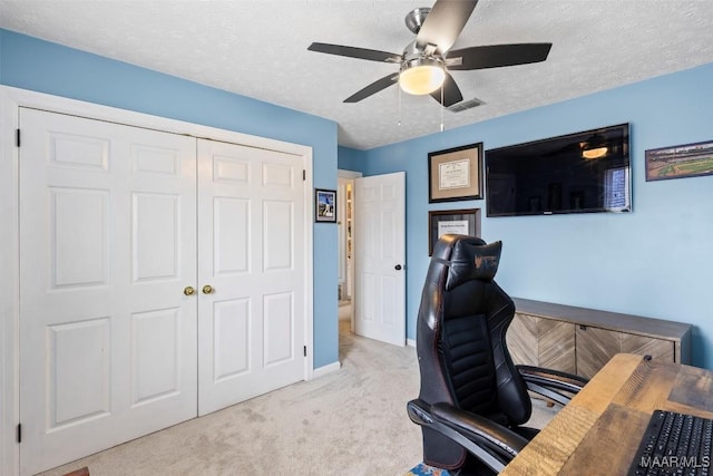 office featuring visible vents, a ceiling fan, carpet flooring, a textured ceiling, and baseboards