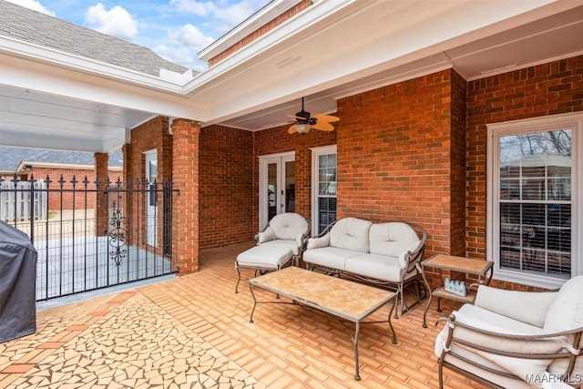 view of patio / terrace with a gate, outdoor lounge area, fence, and a ceiling fan