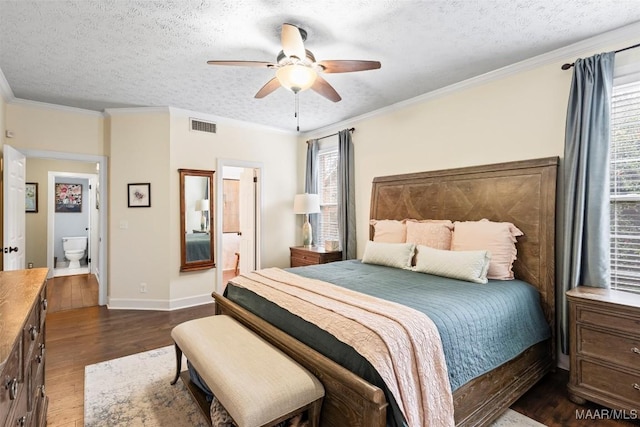 bedroom with ornamental molding, dark wood-style flooring, visible vents, and a textured ceiling