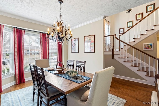 dining area featuring crown molding, a textured ceiling, wood finished floors, baseboards, and stairs