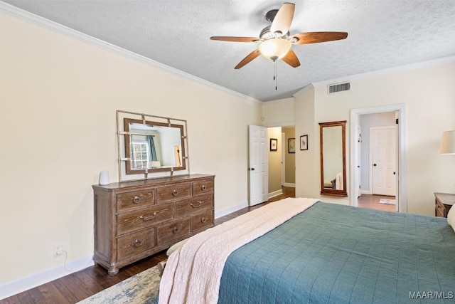 bedroom featuring dark wood-style floors, visible vents, ornamental molding, and a textured ceiling