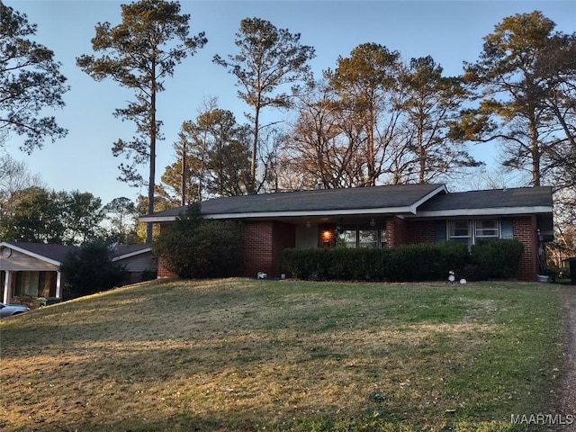 ranch-style house featuring brick siding and a front yard