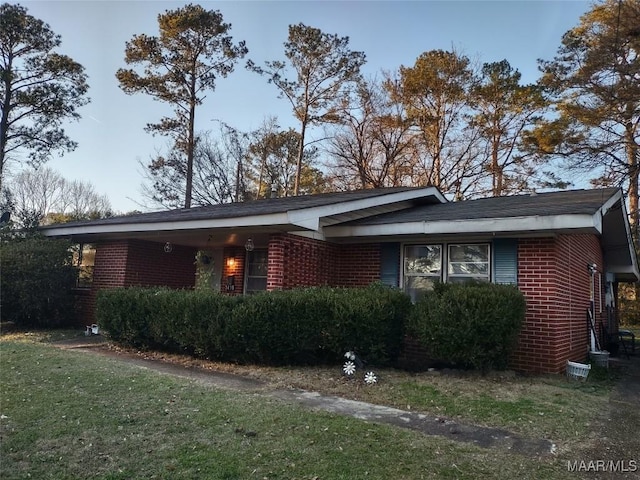 view of front of house featuring a front lawn and brick siding