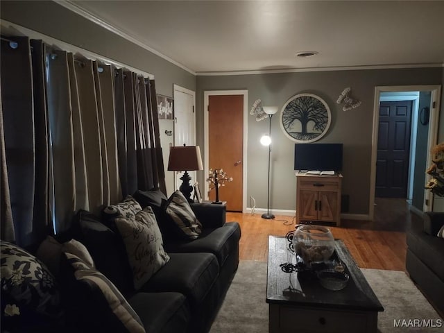 living area with baseboards, wood finished floors, visible vents, and crown molding