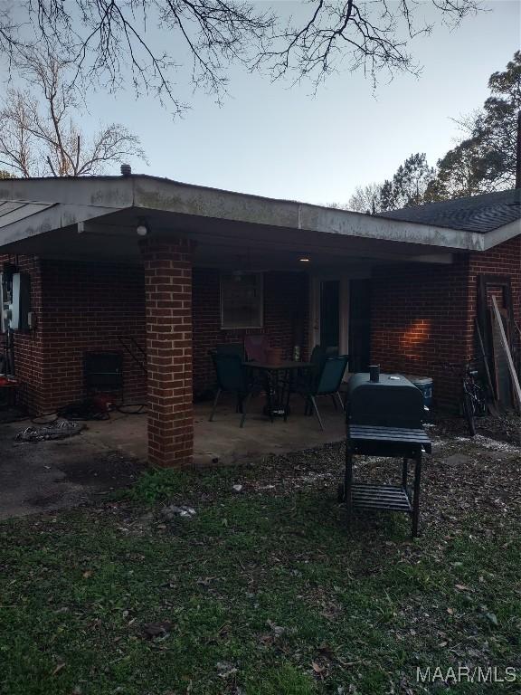 back of house with a patio and brick siding