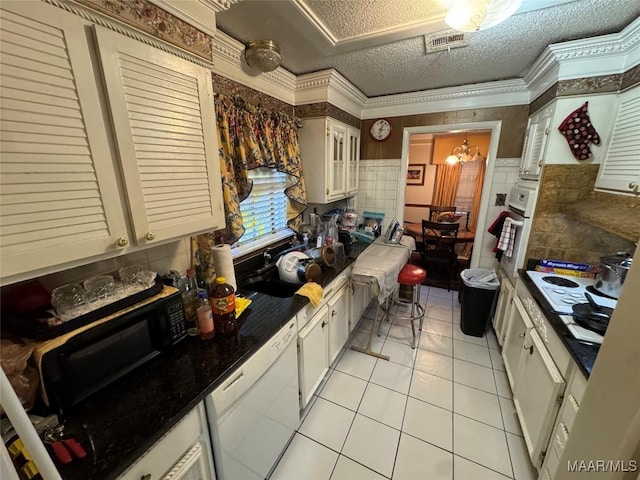 kitchen featuring light tile patterned floors, visible vents, ornamental molding, a textured ceiling, and white appliances