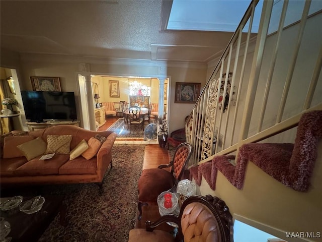 living room featuring stairway, ornate columns, and wood finished floors