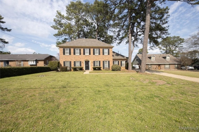 view of front facade with a front yard and brick siding