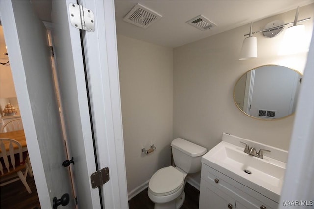 bathroom featuring toilet, baseboards, visible vents, and vanity