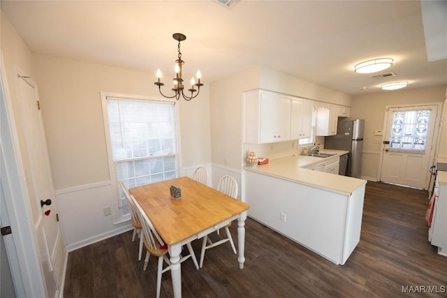 kitchen with light countertops, visible vents, dark wood-type flooring, white cabinetry, and a sink