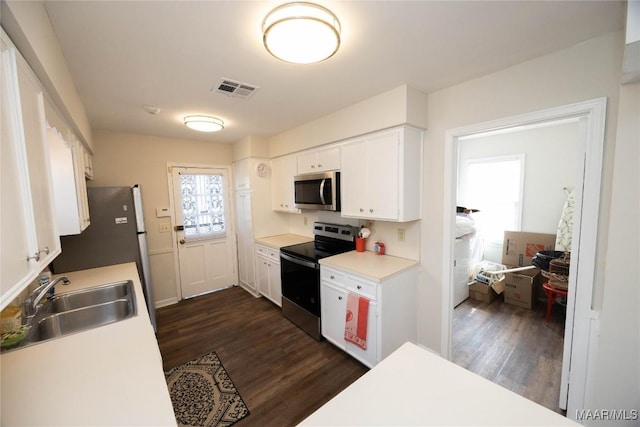 kitchen with white cabinetry, appliances with stainless steel finishes, dark wood-type flooring, and a sink