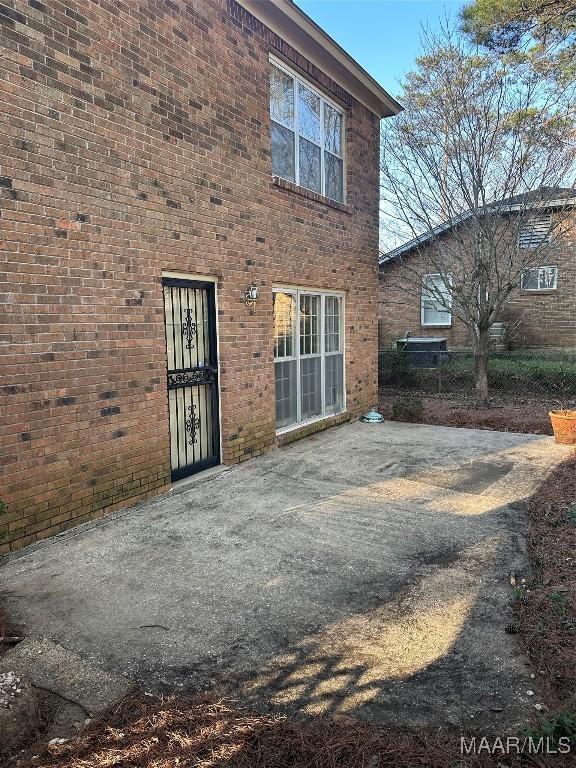 rear view of property featuring a patio area and brick siding