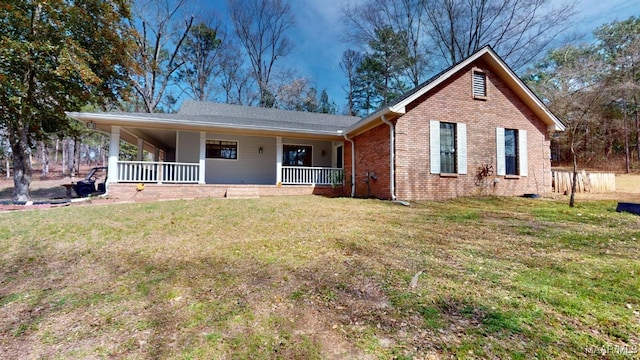 view of front of house with a porch, a front lawn, and brick siding