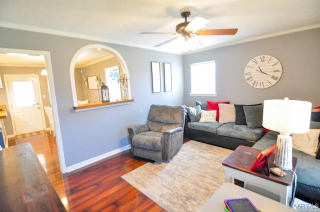 living room featuring ornamental molding, a healthy amount of sunlight, baseboards, and wood finished floors