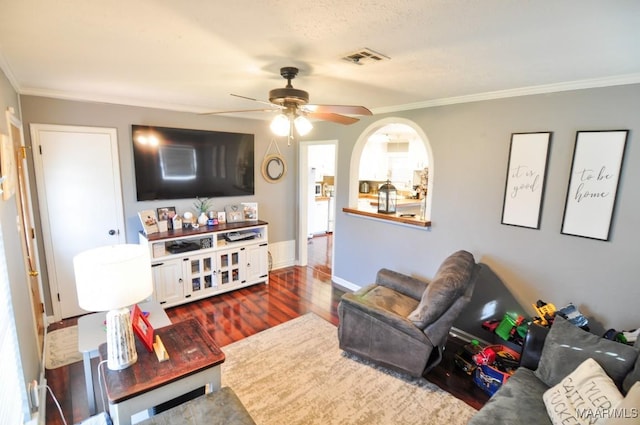 living room featuring dark wood-style floors, visible vents, ornamental molding, and baseboards