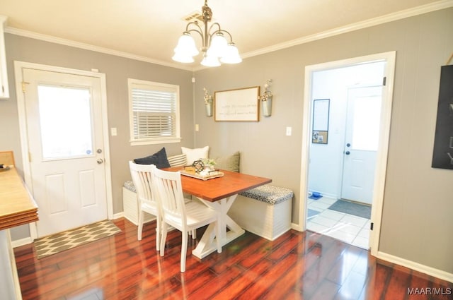 dining room with baseboards, breakfast area, wood finished floors, an inviting chandelier, and crown molding