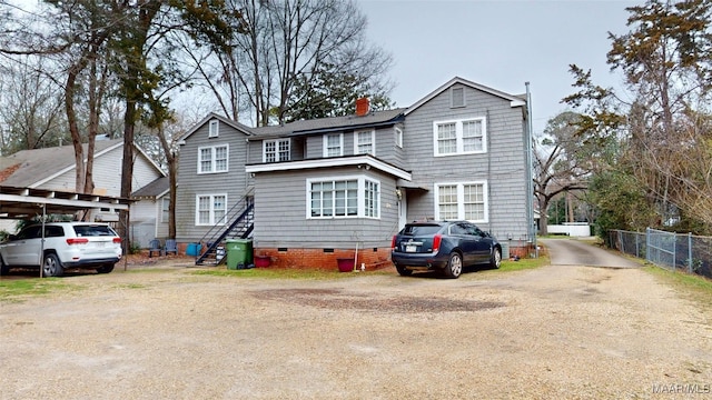 view of front of house featuring crawl space, driveway, a chimney, and fence