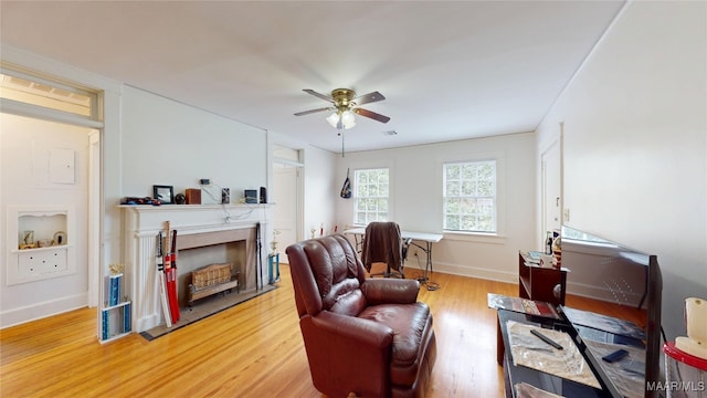 932 E Fairview Ave, Montgomery, AL 36106 - living area with a fireplace, light wood-style flooring, baseboards, and ceiling fan