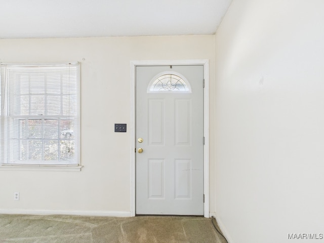 foyer entrance with carpet floors and baseboards