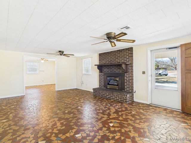 unfurnished living room with a fireplace, visible vents, and baseboards