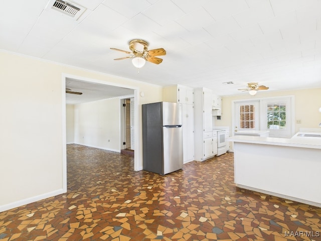 kitchen featuring a sink, visible vents, white cabinetry, light countertops, and freestanding refrigerator