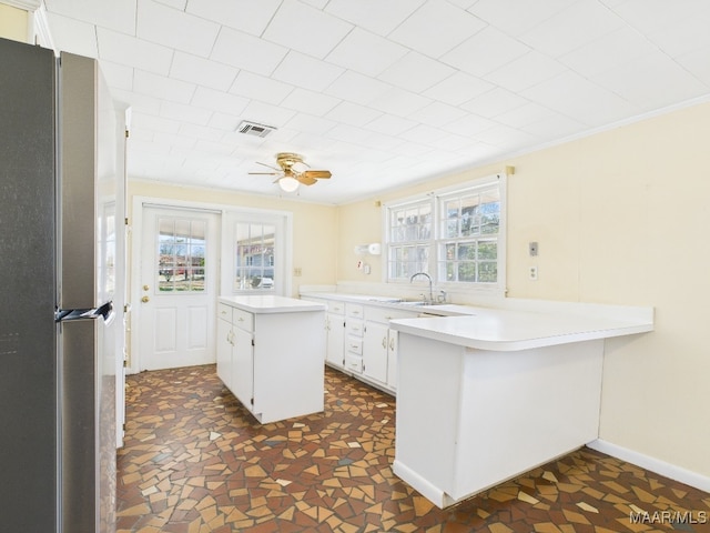 kitchen with freestanding refrigerator, visible vents, plenty of natural light, and a peninsula