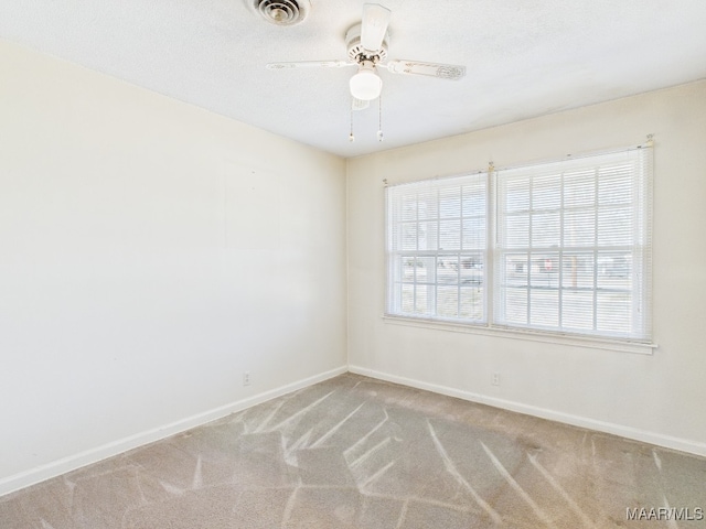 spare room with carpet, visible vents, and baseboards