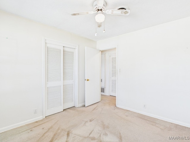 unfurnished bedroom featuring carpet floors, a ceiling fan, baseboards, and a closet