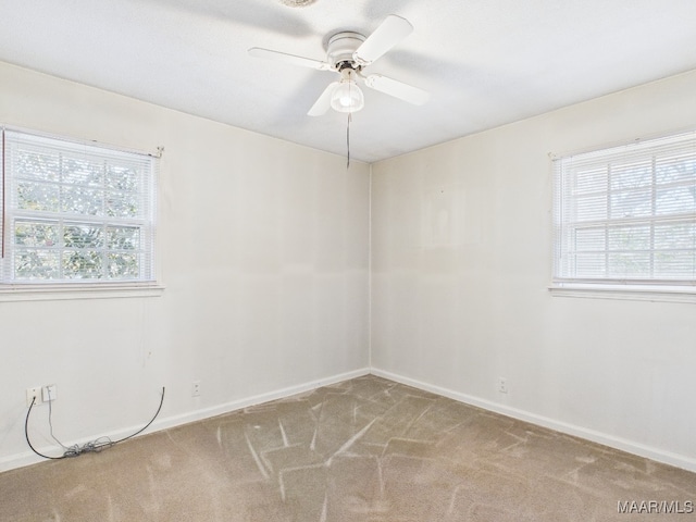 spare room with ceiling fan, carpet floors, and baseboards