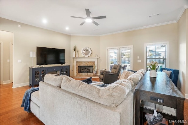 living room with baseboards, visible vents, wood finished floors, and ornamental molding