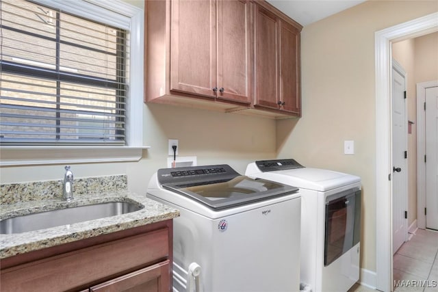 clothes washing area featuring light tile patterned floors, a sink, cabinet space, and washer and dryer