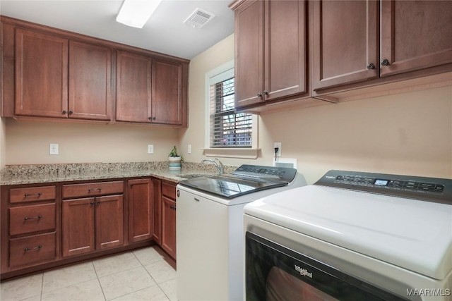 clothes washing area featuring light tile patterned floors, separate washer and dryer, a sink, visible vents, and cabinet space