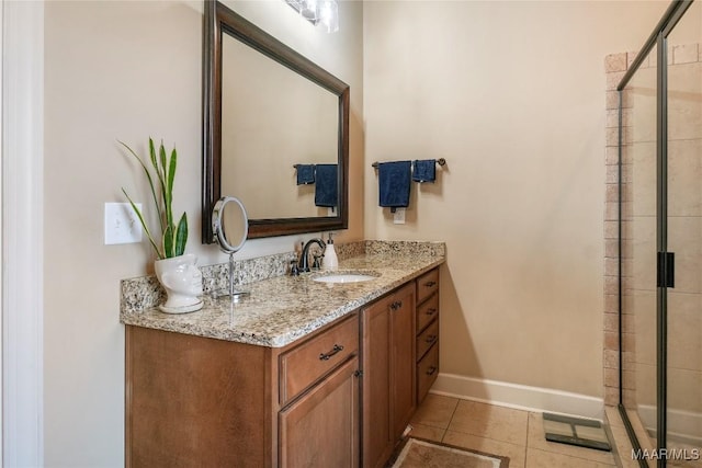 full bathroom featuring baseboards, a stall shower, vanity, and tile patterned floors