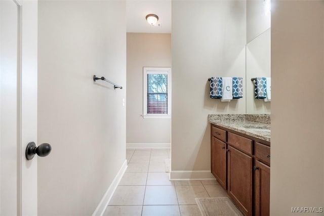 bathroom with tile patterned flooring, baseboards, and vanity