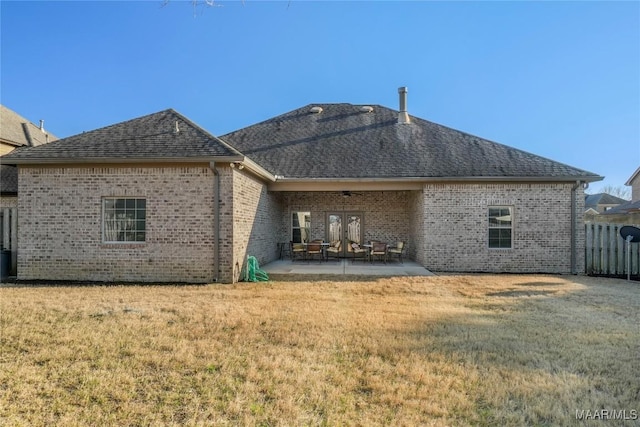 back of house featuring brick siding, ceiling fan, a lawn, and a patio