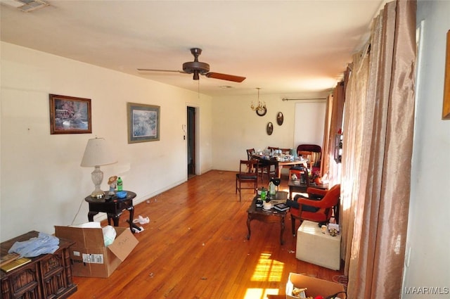 living area featuring a ceiling fan, visible vents, and wood finished floors