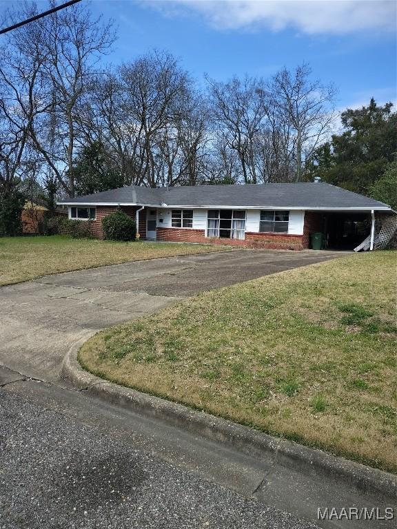 ranch-style home featuring aphalt driveway, a front yard, brick siding, and a carport