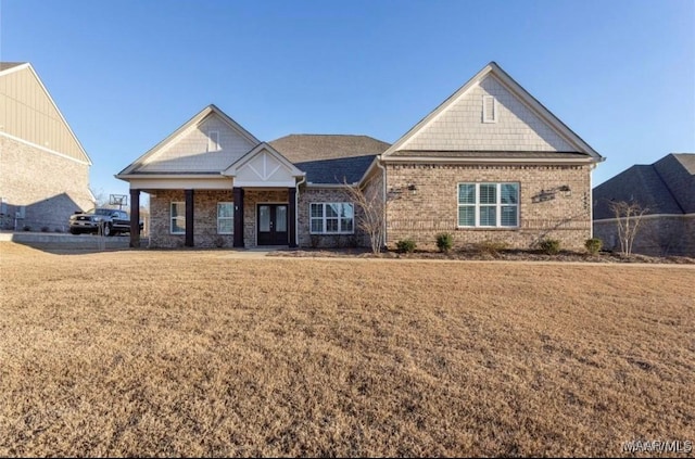 craftsman house featuring french doors, a front yard, and brick siding