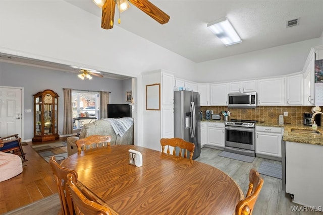 dining area featuring light wood-style flooring, visible vents, and ceiling fan