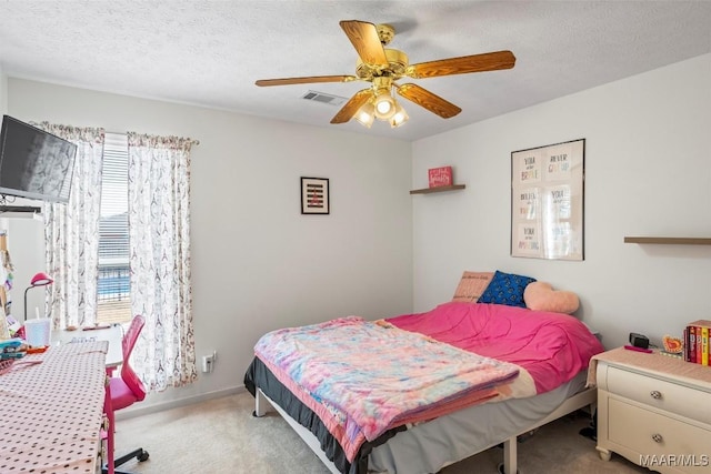 carpeted bedroom featuring visible vents, ceiling fan, and a textured ceiling