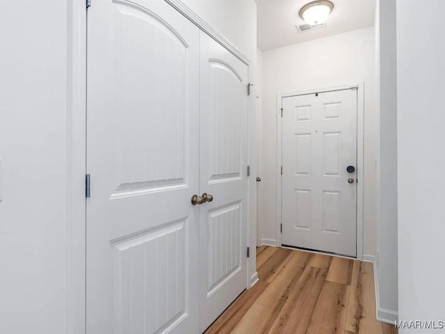 doorway to outside featuring light wood-type flooring, baseboards, and visible vents