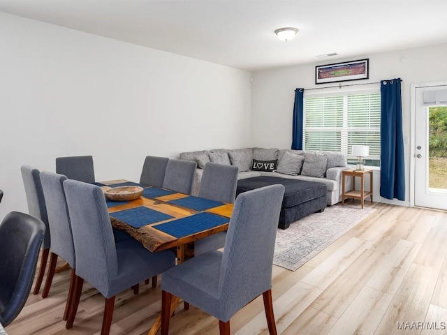 dining space featuring light wood-style flooring and visible vents