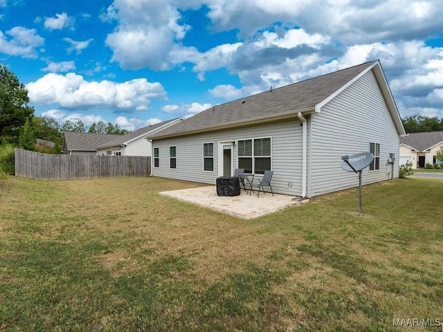 rear view of house with a patio, a yard, and fence