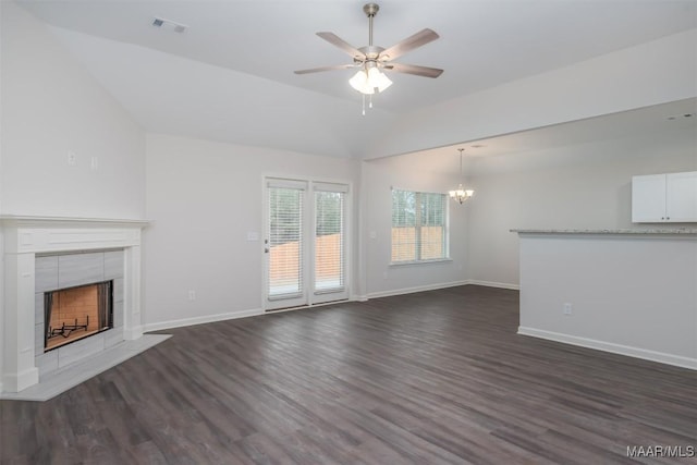 unfurnished living room featuring dark wood-style floors, a tile fireplace, visible vents, and lofted ceiling