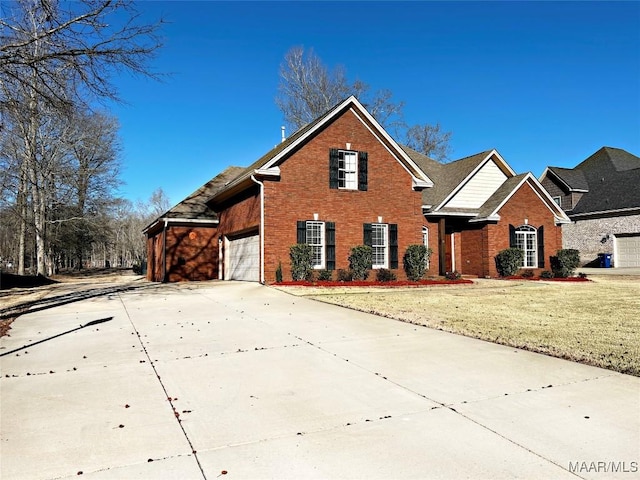 traditional-style home featuring concrete driveway, brick siding, and a front yard