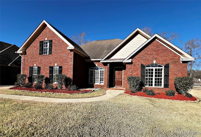 view of front facade with brick siding and a front lawn