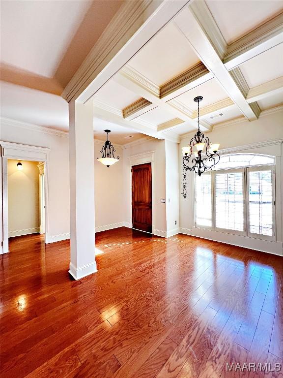 spare room with ornamental molding, beamed ceiling, coffered ceiling, and wood finished floors